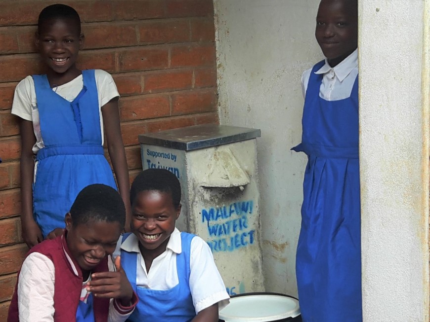 馬拉威兒童在學校的濾水器旁露出開心的笑容